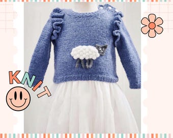 May include: A blue knitted sweater with a white and gray sheep applique. The sweater has ruffles on the shoulders and is made for a child.