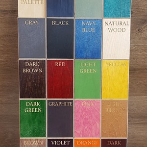 May include: Woodpower's color palette chart with 16 different wood stained colors, including dark blue, light blue, turquoise, gray, black, navy blue, natural wood, dark brown, red, light green, yellow, dark green, graphite, pink, light brown, brown, violet, orange, and dark red.