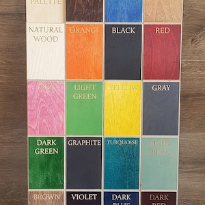 May include: A colour palette chart with 18 different wood stain colours. The colours include dark brown, navy blue, light brown, orange, black, red, pink, light green, yellow, grey, dark green, graphite, turquoise, light blue, brown, violet, dark blue, and dark red.