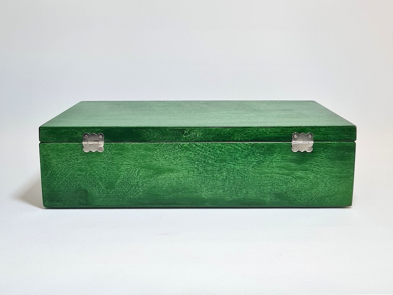 May include: A green wooden box with silver hinges. The box is closed.