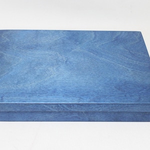 May include: A blue wooden box with a smooth, polished finish. The box is closed and has a rectangular shape.