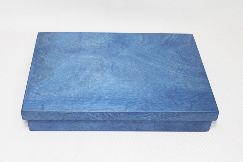 May include: A blue wooden box with a smooth, polished finish. The box is closed and has a rectangular shape.