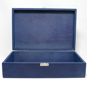 May include: A dark blue wooden box with a hinged lid and a silver latch. The box is open and empty.