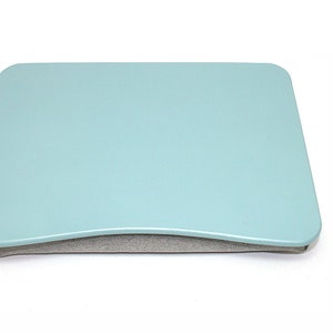 May include: A light blue laptop desk with a gray padded cushion. The desk is designed to be used on a bed or couch.