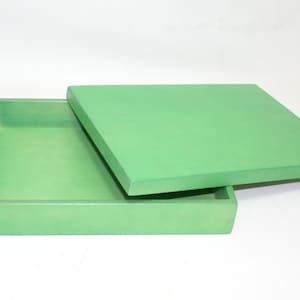 May include: A square, green wooden box with a lid. The lid is open and the box is empty.