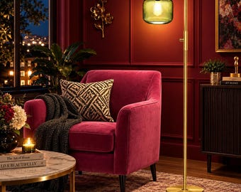 May include: A floor lamp with a slender gold-toned metal stand and a circular base, featuring a ribbed, translucent green glass shade that emits a warm glow. The lamp has an adjustable arm and a simple switch on the vertical pole.