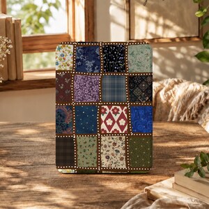 Könnte beinhalten: Eine rechteckige Tablethülle mit einem Patchwork-Design aus verschiedenen Stoffmustern, darunter Blumenprints, Karos, Punkte und geometrische Formen in Blau-, Grün-, Rot- und Brauntönen, getrennt durch braune Ränder mit weißen Punkten.
