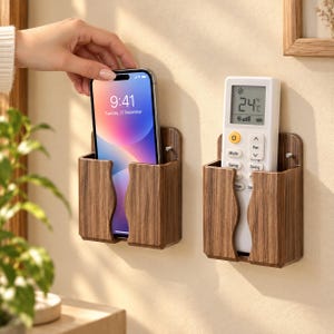 May include: Two wall-mounted storage holders with a dark brown wood grain finish. One holder contains a smartphone with a colorful screen display, and the other holds a white remote control with a digital screen showing 24 degrees Celsius.