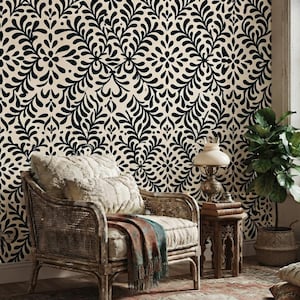 May include: A wallpaper featuring a repeating black botanical pattern on a cream background. The design consists of symmetrical, leaf-like shapes arranged in a dense, interconnected grid that covers the entire surface of the wall.