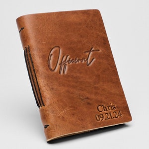 May include: A brown leather journal with the word "Offiant" embossed on the front cover. The journal also has the name "Chris" and the date "09.21.24" embossed on the front cover.