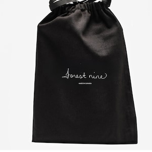 May include: A black fabric drawstring pouch featuring a black ribbon closure at the top. The front of the bag displays the white text "forest nine" in a cursive script, with the words "MADE IN CANADA" printed in smaller capital letters below.