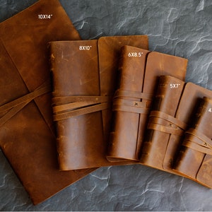 May include: Five brown leather journals of different sizes, with the measurements 10x14", 8x10", 6x8.5", 5x7", and 4x6" printed on the covers. The journals are tied with leather straps.