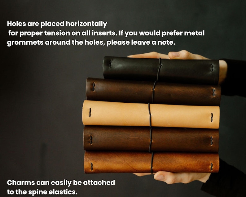 May include: A stack of leather journals in various shades of brown and tan, held by a person. The journals are bound with black elastic and feature horizontal holes. Text on the image mentions the option for metal grommets and charm attachment.
