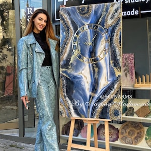 May include: A rectangular wall clock featuring a blue, white, and black marbled resin design with gold accents and textured crystal-like edges. The clock face has gold Roman numerals and gold hands. The text @SEVNARMS By Narmin Muslumzade is visible.