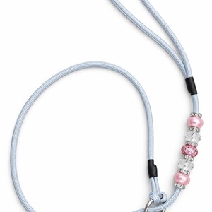 May include: A light blue rope leash featuring a loop handle and a silver metal ring at the end. The leash is decorated with a series of alternating pink pearl-like beads, clear faceted crystal beads, and small silver-toned rhinestone spacers.