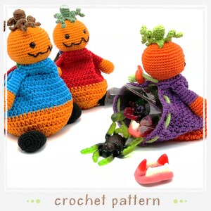 Op de afbeelding: Drie gehaakte pompoenfiguren, één met een zak snoep. De pompoenen zijn oranje met verschillende gekleurde kleding. De zak is paars met een groene bovenkant en is gevuld met snoep. De pompoenen zijn een Halloween-gehaakt patroon.