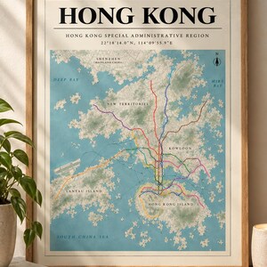 May include: A framed map print of Hong Kong featuring the text HONG KONG, HONG KONG SPECIAL ADMINISTRATIVE REGION, and coordinates. The map displays the region's geography in blue and green with a colourful transit network overlaying the land.