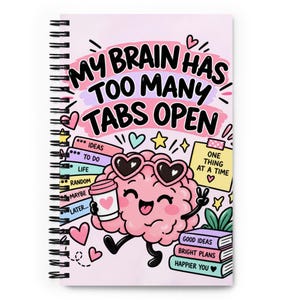 May include: A spiral-bound notebook with a light pink cover featuring a cartoon brain wearing heart-shaped sunglasses, holding a coffee cup, and the text "MY BRAIN HAS TOO MANY TABS OPEN" along with "ONE THING AT A TIME" and various labels.