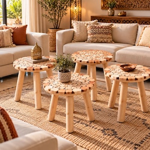 Peut inclure: Un ensemble de trois tables d'appoint rondes, chacune dotée d'un plateau composé de nombreuses petites tranches de bois clair assemblées, reposant sur trois pieds cylindriques robustes en bois clair.