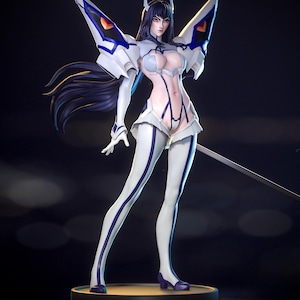 May include: A standing anime-style figurine of a character with long dark hair, wearing a white and blue bodysuit with large shoulder armor pieces. The figure features a high-cut design, white thigh-high leg coverings, and stands on a circular base.