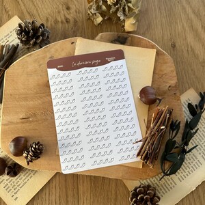 May include: A rectangular sticker sheet with a brown header featuring the text "La dernière page" and "Notation Spicy" alongside the year "2026". The sheet contains a grid of small, black, outlined chilli pepper icons on a white background.