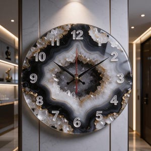 May include: A round wall clock featuring a black and white agate-inspired design with crystalline textures and gold-toned accents. The clock face displays silver-colored numerals from 1 to 12, with black hour and minute hands and a red second hand.