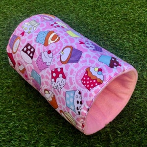May include: Pink and white fabric tube with a cupcake pattern. The tube is lined with soft pink fabric.