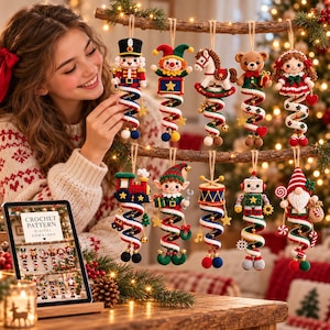 May include: A collection of ten crocheted Christmas ornaments hanging from a branch, including a nutcracker, jester, rocking horse, teddy bear, doll, train, elf, drum, robot, and gnome, each featuring a colorful spiral base with small charms.