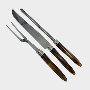 May include: A carving set featuring a fork, knife, and sharpening steel. The stainless steel blades and tines are paired with handles that have a dark brown and yellow-brown pattern, accented with silver-colored metal.