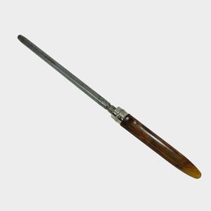 Puede incluir: Un afilador de cuchillos con un mango marr&oacute;n y una varilla de acero plateado. El mango tiene forma redondeada y est&aacute; hecho de un material marr&oacute;n oscuro. La varilla de acero es larga y delgada.