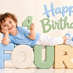 Peut inclure: Un enfant aux cheveux bruns boucl&eacute;s porte un t-shirt bleu clair et un pantalon blanc, allong&eacute; sur de grandes lettres en bloc de couleur pastel formant le mot FOUR. L'enfant tient un chiffre 4 vert, avec le texte Happy Birthday en bleu et vert.