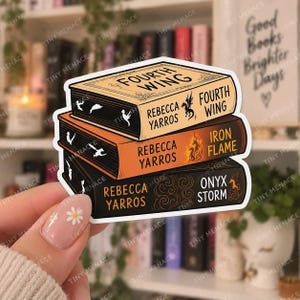 Pode incluir: Um adesivo recortado com uma pilha de três livros com bordas pretas. O livro de cima é bege com o texto Fourth Wing, o do meio é laranja com o texto Iron Flame e o de baixo é preto com o texto Onyx Storm.
