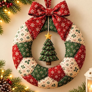May include: A quilted fabric Christmas wreath featuring alternating red and green panels with snowflake and holly patterns. A large red fabric bow sits at the top, and a small, stuffed green Christmas tree ornament with a yellow star hangs in the center.