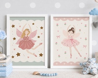 May include: Two framed wall art prints featuring illustrations of fairies in pink ballet attire. The left print shows a fairy with blonde hair and gold stars, while the right print displays a fairy with a bun surrounded by small pink flowers and bows.