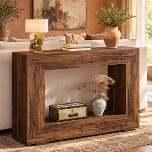 May include: A rectangular wooden console table with a dark brown, weathered wood grain finish. The table features a thick, hollow frame design with a lower shelf holding a small, rectangular trunk with a Union Jack pattern and a light blue ceramic vase.