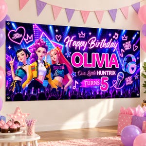 May include: A rectangular birthday banner featuring three illustrated characters in a concert setting with neon blue and purple lighting. The text reads Happy Birthday OLIVIA Our Little HUNTRIX TURNS 5, surrounded by musical notes, hearts, and stars.