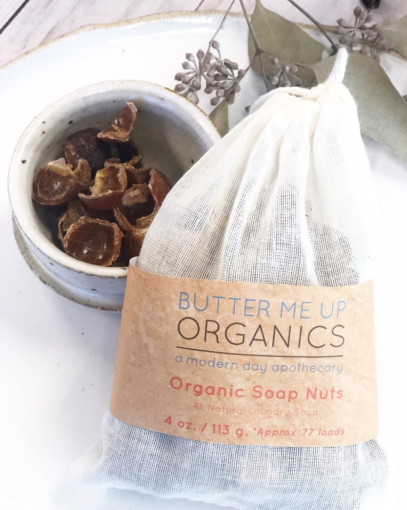 May include: A white muslin bag filled with brown soap nuts, labeled "Butter Me Up Organics, a modern day apothecary, Organic Soap Nuts, All Natural Laundry Soap, 4 oz. / 113 g. Approx. 77 loads."