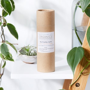 May include: A brown cardboard tube with a white label that reads "BUTTER ME UP. ORGANICS modern day apothecary No Funky Junk Men's Talc Free Powder 80 ml".