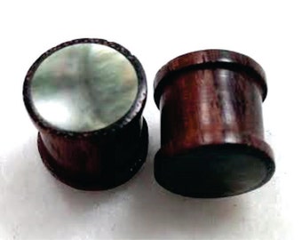 May include: Pair of wooden ear gauges with a mother of pearl inlay. The gauges are dark brown with a natural wood grain.