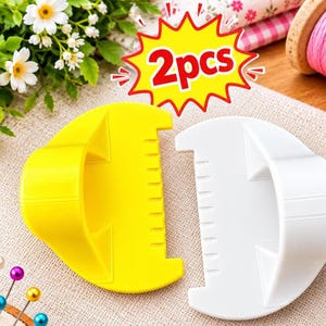 May include: Two semi-circular plastic sewing tools, one yellow and one white, each featuring a handle and a notched edge. A graphic overlay in the centre displays the red text 2pcs inside a yellow starburst shape with red outlines.