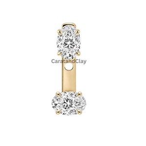 Peut inclure: Une veste de boucle d'oreille en or avec deux diamants blancs taille ovale sertis sur griffes. Le diamant supérieur est orienté verticalement et le diamant inférieur horizontalement, reliés par une barre en or. Le texte CaratandClay est visible.