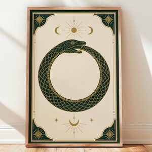 May include: A rectangular framed wall art print featuring a dark green ouroboros snake eating its own tail in a circular shape. The design includes gold celestial motifs like suns and moons on a cream background with dark green corner accents.