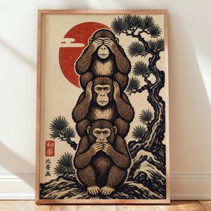 May include: A framed art print featuring three stacked monkeys in a woodblock style. The top monkey covers its eyes, the middle covers its ears, and the bottom covers its mouth. A large red sun and a black pine tree are in the background with Japanese text.