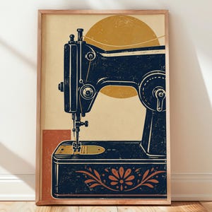 Könnte beinhalten: Ein gerahmter Wandkunstdruck mit einer dunkelblauen Vintage-Nähmaschine vor einem cremefarbenen Hintergrund. Ein großer senfgelber Kreis befindet sich hinter der Maschine, mit einem terrakottafarbenen Rechteck darunter und einem Blumenmotiv.