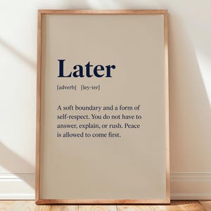May include: A framed wall art print featuring a dictionary-style definition of the word Later. The text is printed in dark blue on a light beige background. It includes the phonetic pronunciation and a definition about boundaries and self-respect.