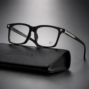 Puede incluir: Gafas rectangulares negras con lentes transparentes y detalles de metal plateado en las patillas y esquinas del marco. Las patillas presentan intrincados detalles grabados. Un estuche negro de aspecto cuero con el texto Chrome Hearts en relieve.