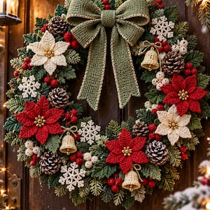 Op de afbeelding: Een gehaakte kerstkrans met een grote saliegroene strik aan de bovenkant, rode en crèmekleurige kerststerren, witte gehaakte sneeuwvlokken, kleine beige belletjes, bruine dennenappels en trossen rode bessen tussen groen loof.