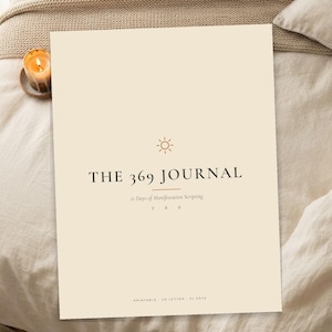 Op de afbeelding: Een crèmekleurige journal-omslag met de tekst THE 369 JOURNAL, 21 Days of Manifestation Scripting, 3 6 9, PRINTABLE, US LETTER, 21 DAYS, en een klein zon-icoon in donkerbruine inkt gecentreerd op de voorzijde van de rechthoekige pagina.