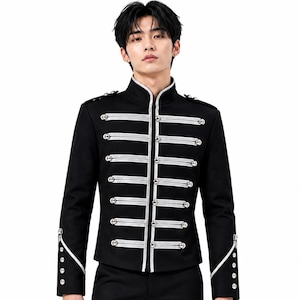 May include: A black military-style jacket featuring a high collar, long sleeves, and silver-toned braided cord detailing across the front. The garment includes silver buttons along the center closure, shoulder epaulets, and cuffs, with white piping.