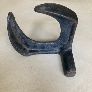 Puede incluir: Un horma de zapato de hierro fundido negro, una herramienta utilizada por los zapateros para dar forma y estirar los zapatos de cuero.